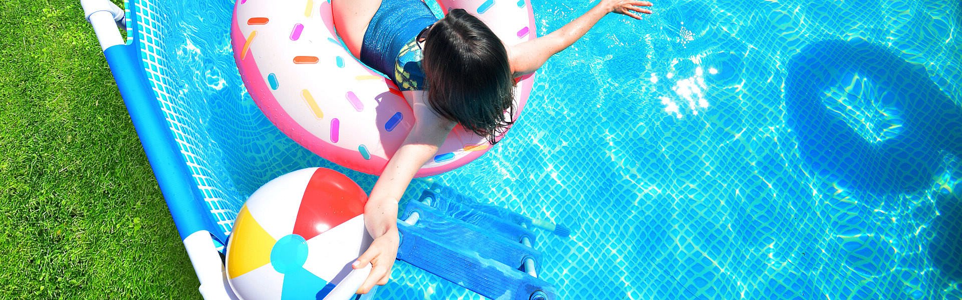 Frau lässt sich auf einem aufblasbaren Donut im Pool treiben