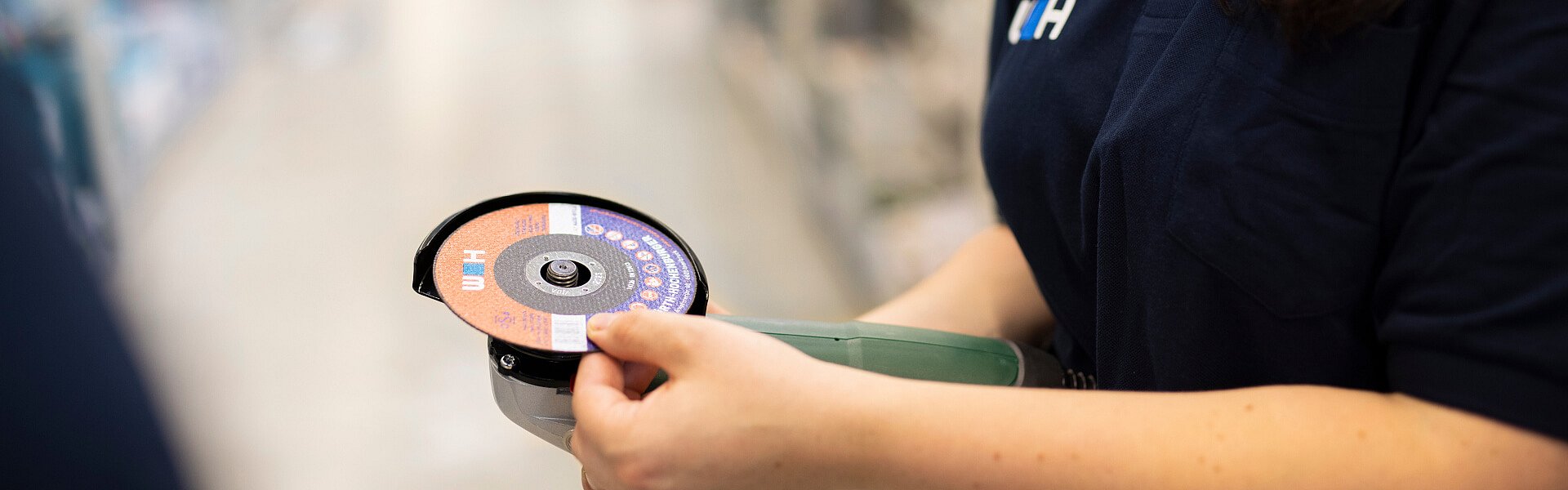 WH-Mitarbeiter führt einen Winkelschleifer vor