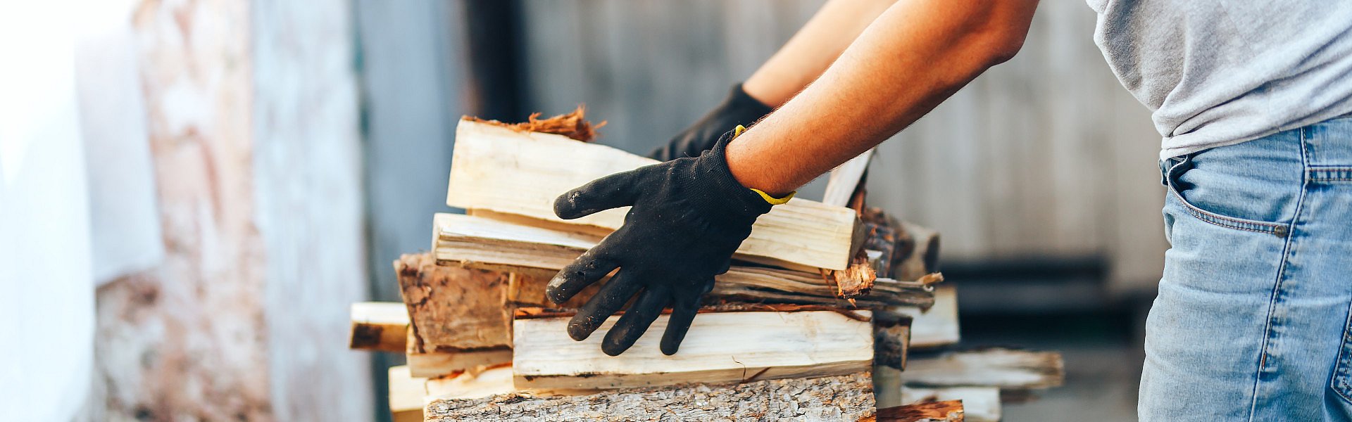 Frau stapelt Brennholzscheite