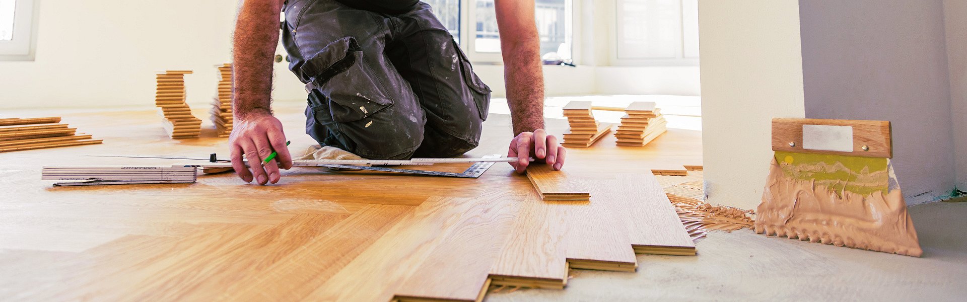 Handwerker verlegt einen Fischgrät-Parkett