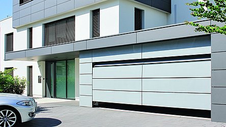 Einfamilienhaus mit Rolltor welches Zugang zur Garage regelt.
