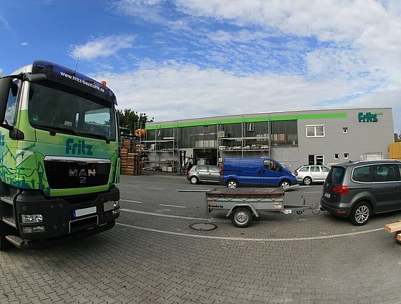 LKW und Autos auf dem Parkplatz der Fritz Baustoffe Filiale Ottobrunn
