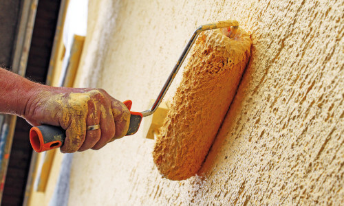 Außenfassade eines Einfamilienhauses wird neu in gelb gestrichen