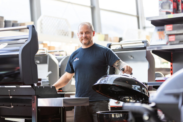 WH-Mitarbeiter in der Grill-Abteilung im Baumarkt